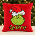 Red Grinch Cushion with evergreen branches and golden Christmas lights