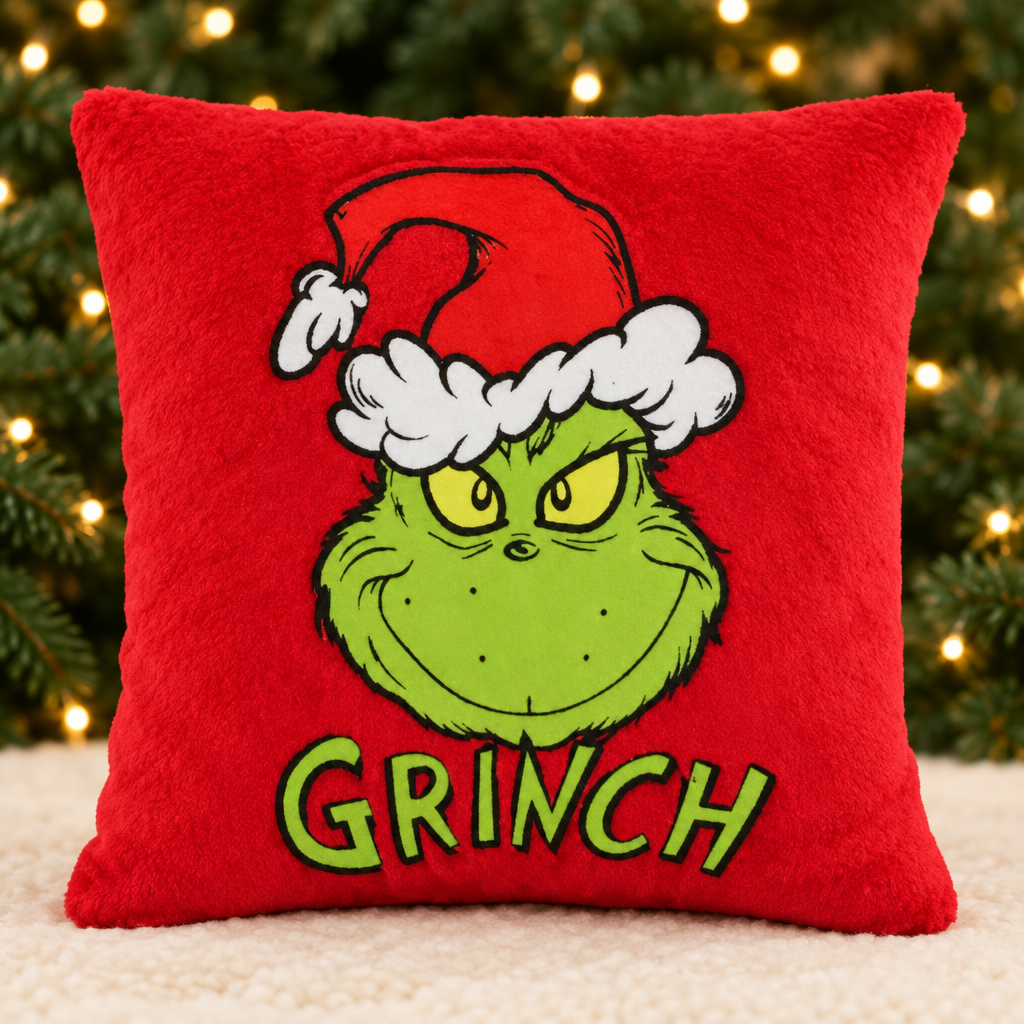 Red Grinch Cushion with evergreen branches and golden Christmas lights