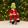 Animated Grinch on Tricycle with a green and gold Christmas background